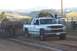 1994 Ford F-150 - A white Chevrolet Silverado truck competes in a pull event, dragging a sled across the dirt track.