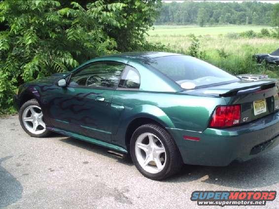 Green Ford Mustang coupe with flame decals on the side, rear spoiler, and GT badge