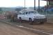 1994 Ford F-150 - A pickup truck competes in a pull event, dragging a heavy trailer across a dirt track.