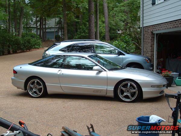 Silver 1993 Ford Probe GT parked next to a blue SUV in a driveway