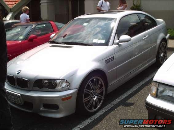 Silver BMW E46 M3 coupe parked next to a red car and a white car