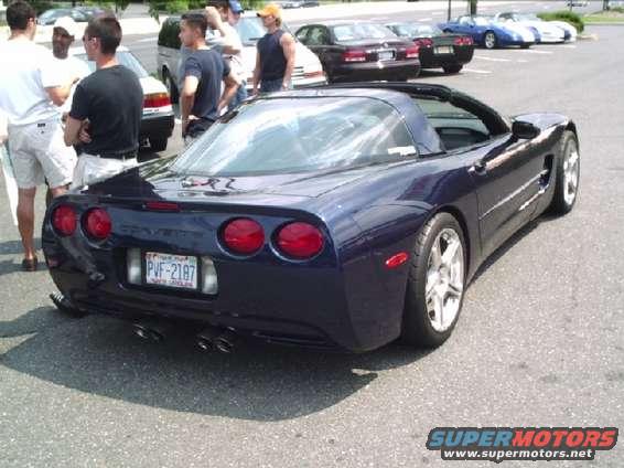 Dark blue Chevrolet Corvette C5 with quad exhaust pipes and a license plate reading PVF-2187