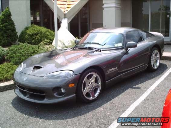 Gray Dodge Viper parked in front of a building with bushes