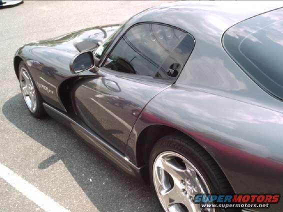 Side view of a dark gray Dodge Viper. It has a scoop on the hood and a distinctive side vent