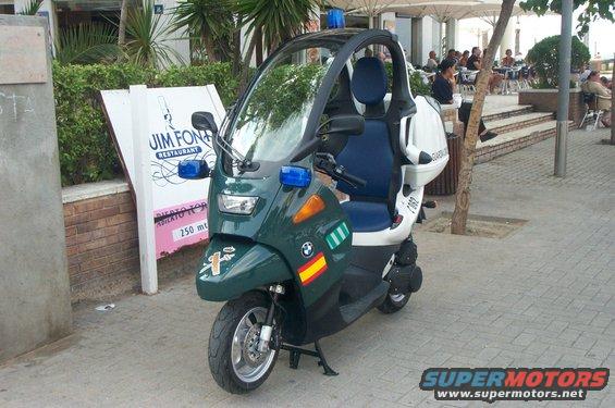 Green three-wheeled scooter with canopy, blue lights, and Guardia Civil markings