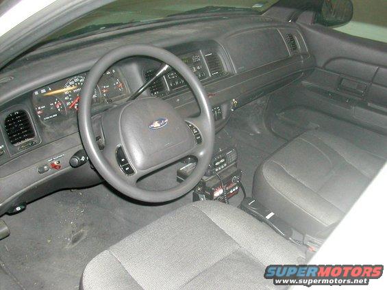 Interior of a 1991 Ford Crown Victoria police car, showing the dashboard, steering wheel, and front seats