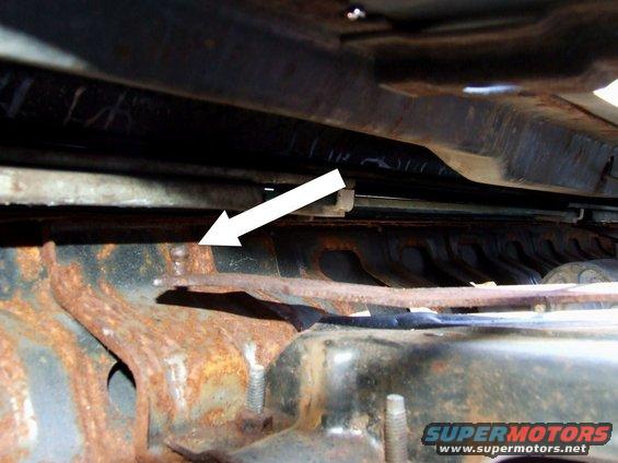 Rusty metal frame with arrow pointing to bolt