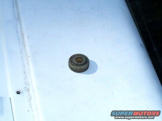 Rubber bumper part on a white surface. Supermotors.net logo visible