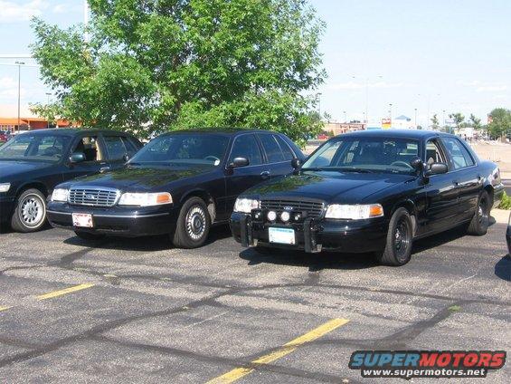 1999 Ford Crown Victoria, front 3/4 view, black, with push bar