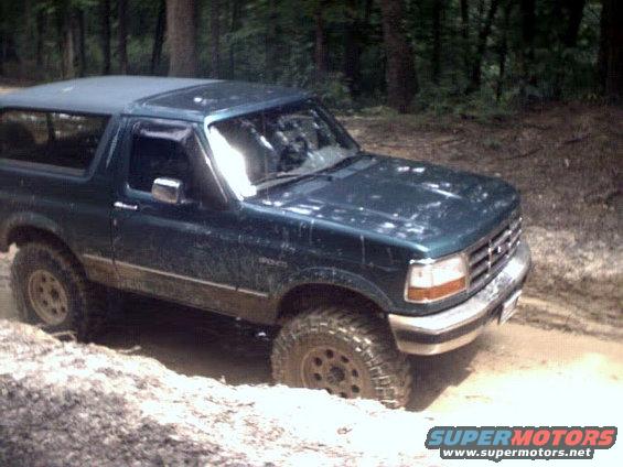 1996 Ford Bronco stuck in mud on a wooded trail