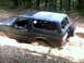 1996 Ford Bronco - A 1996 Ford Bronco navigates a muddy trail, with its rear spare tire mounted externally.