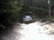 1996 Ford Bronco - A 1997 Ford F-250 navigates a challenging dirt path through a wooded area.