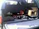 1996 Ford Bronco - The cargo area of an SUV is filled with various items, including tools and a red gas can.