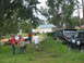 1995 Ford C-350 (Centurion Conversions) - Two SUVs are parked in a grassy area with people nearby. One SUV is a 1992 Ford Bronco.