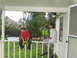 1995 Ford C-350 (Centurion Conversions) - Two young males sit on a porch railing, with debris and downed trees visible in the background.