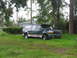 1995 Ford C-350 (Centurion Conversions) - This 1995 Ford C-350 Centurion conversion SUV is seen parked in a grassy area with trees and a house in the background.