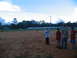 1995 Ford C-350 (Centurion Conversions) - Players and spectators gather on a baseball field during a game.