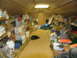 1995 Ford C-350 (Centurion Conversions) - A cluttered storage room contains shelves stocked with containers, buckets, and tools.