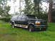 1995 Ford C-350 (Centurion Conversions) - A dark green Ford SUV with tan trim is parked on a grassy area.