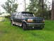 1995 Ford C-350 (Centurion Conversions) - This dark green SUV with tan trim is parked on a grassy area, seen from a 3/4 front angle. The vehicle appears to be a mid-1990s model.