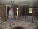 1995 Ford C-350 (Centurion Conversions) - Two individuals are engaged in the process of clearing debris from a damaged interior space, likely after a disaster.