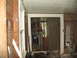 1995 Ford C-350 (Centurion Conversions) - The interior of a room shows signs of damage and renovation, with appliances visible through a doorway.