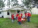 1995 Ford C-350 (Centurion Conversions) - Volunteers gather with wheelbarrows in front of a house, likely for disaster relief efforts.