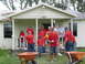 1995 Ford C-350 (Centurion Conversions) - A group of volunteers appears to be preparing for or cleaning up after an event at a residential property.