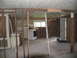 1995 Ford C-350 (Centurion Conversions) - The interior of a room shows significant damage with exposed studs and debris, indicating a need for renovation.