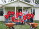 1995 Ford C-350 (Centurion Conversions) - A group of volunteers in red shirts pose for a photo in front of a house, likely during a disaster relief effort.