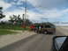 1995 Ford C-350 (Centurion Conversions) - People push a brown SUV on the side of a road under a cloudy sky.