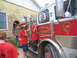 1995 Ford C-350 (Centurion Conversions) - Two boys in red shirts stand next to a fire truck with 'Waveland Fire Dept.' written on the side.