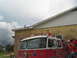 1995 Ford C-350 (Centurion Conversions) - A red fire truck with children on its roof and sides is parked in front of a yellow brick building.