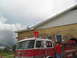 1995 Ford C-350 (Centurion Conversions) - A boy stands on the roof of a Waveland Fire Department truck with his arms wide open, while others gather around the vehicle.