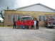 1995 Ford C-350 (Centurion Conversions) - A group of people, likely firefighters or trainees, pose in front of a fire truck outside a building.