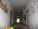 1995 Ford C-350 (Centurion Conversions) - Interior hallway shows damage to walls and ceiling, with an arched exit visible at the far end.