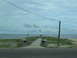 1995 Ford C-350 (Centurion Conversions) - A memorial site with an American flag stands near the ocean on a cloudy day.