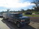 1995 Ford C-350 (Centurion Conversions) - A 1995 Ford C-350 Centurion conversion van is seen towing a trailer on a road, with another vehicle in the background.