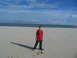 1995 Ford C-350 (Centurion Conversions) - Boy stands on a sandy beach, casting a long shadow under a partly cloudy sky.