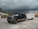 1995 Ford C-350 (Centurion Conversions) - A dark green Ford SUV tows a white trailer under a stormy sky.