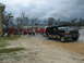 1995 Ford C-350 (Centurion Conversions) - A black Ford Bronco SUV is parked near fire trucks and a group of people in red shirts, possibly during a relief effort.
