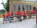 1995 Ford C-350 (Centurion Conversions) - Volunteers in red shirts work together to move tables outside a building, possibly for an event or disaster relief effort.