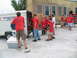 1995 Ford C-350 (Centurion Conversions) - A group of Boy Scouts are seen unloading supplies from a trailer next to a brick building.