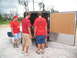 1995 Ford C-350 (Centurion Conversions) - Volunteers in red shirts load supplies into a trailer, with one shirt displaying the SEMA logo.