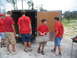 1995 Ford C-350 (Centurion Conversions) - Boys in red SEMA shirts are seen unloading supplies from a trailer.