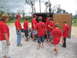 1995 Ford C-350 (Centurion Conversions) - People in red shirts with hurricane and SEVA logos are gathered around an open trailer.