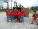1995 Ford C-350 (Centurion Conversions) - A group of people, some wearing red shirts with 'SEMA' printed on them, are gathered around an open trailer.