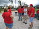 1995 Ford C-350 (Centurion Conversions) - A group of people in red shirts are gathered outdoors, with a silver pickup truck in the background.
