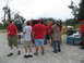 1995 Ford C-350 (Centurion Conversions) - People wearing red shirts are gathered around supplies, with a van visible in the background.