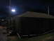 1995 Ford C-350 (Centurion Conversions) - Temporary shelters are set up, likely for disaster relief, under a dark sky with bright floodlights.